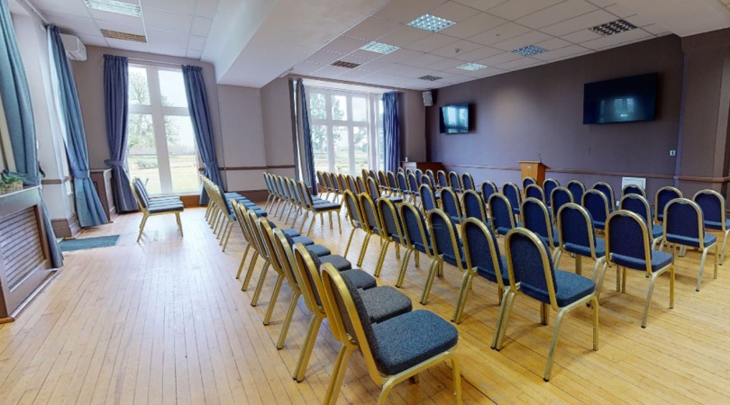 Large conference hall with stage and rows of chairs