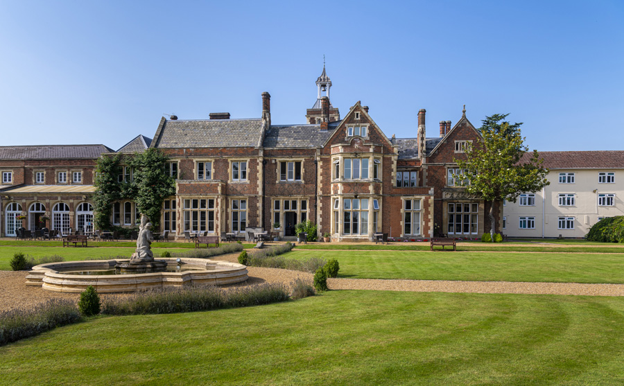 A stunning photo of High Leigh and it's grounds along with the fountain and green grass