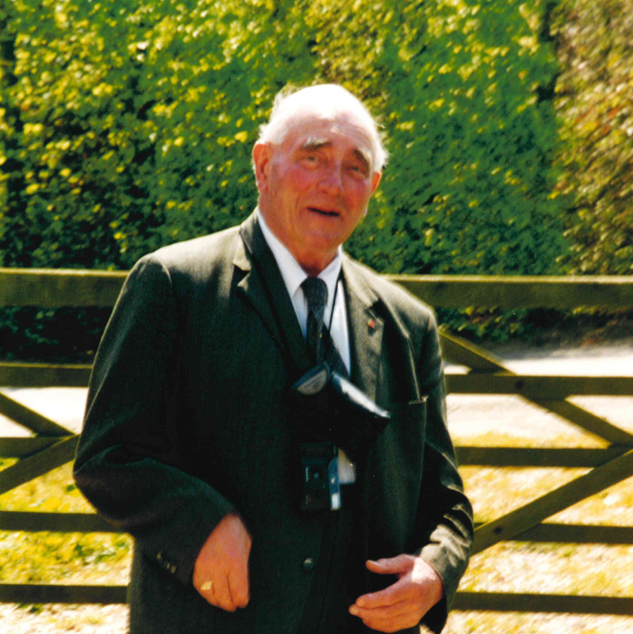 Heinz Mollenbrok standing in front of a fence