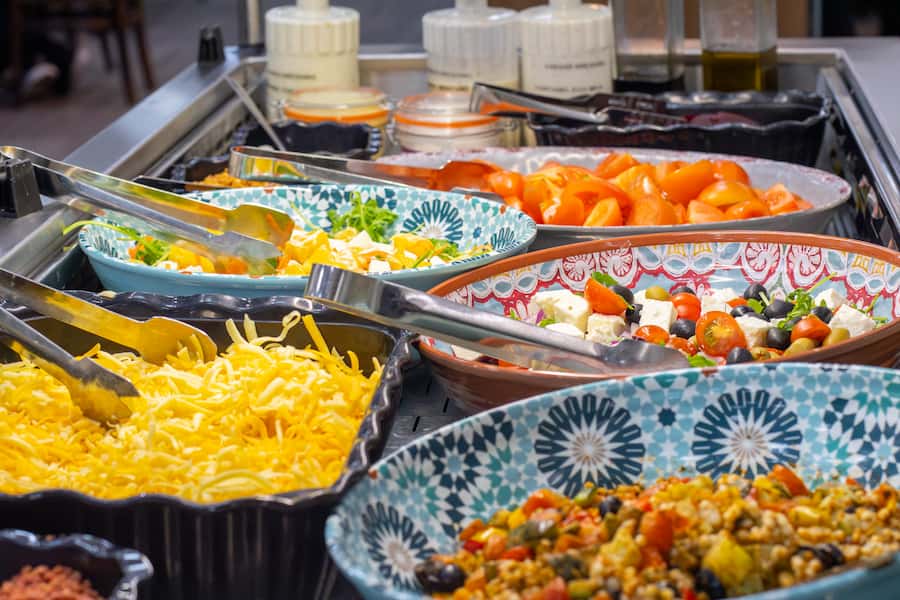 Several bowls of different colourful salads in the buffet chiller at The Hayes.
