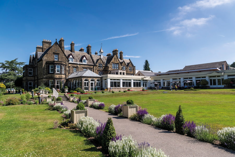 The Hayes conference centre showing its gardens with green grass and a clear blue sky.