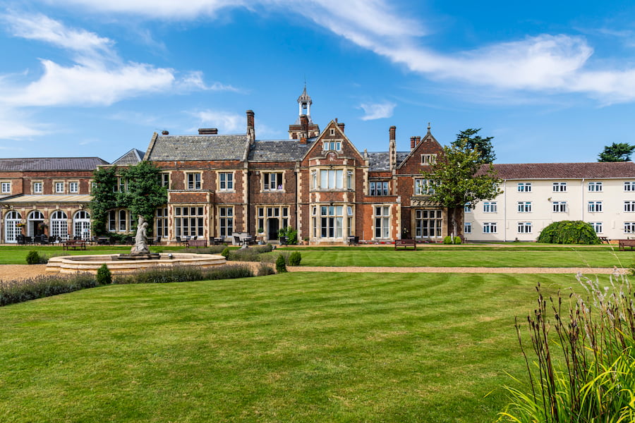 High Leigh conference centre with it's fountain and gardens including freshly cut grass and clear blue sky.