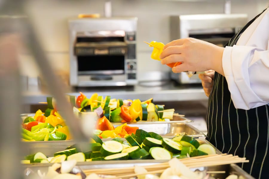 The chef carefully preparing vegetarian skewers.