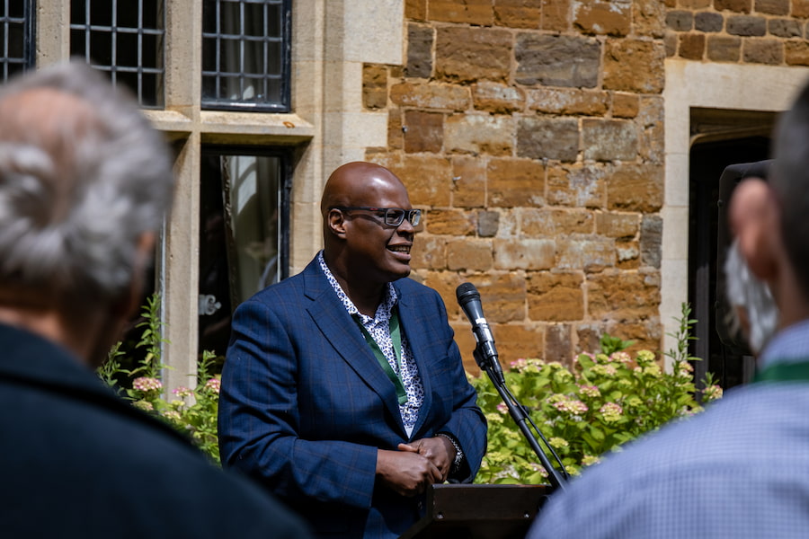 Bishop Mike Royal speaking to a crowd of people at the Highgate House Dedication Ceremony.