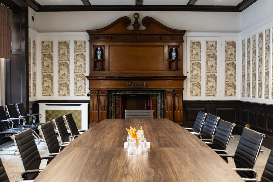 The fireplace in The Boardroom showing off the detailed woodwork.