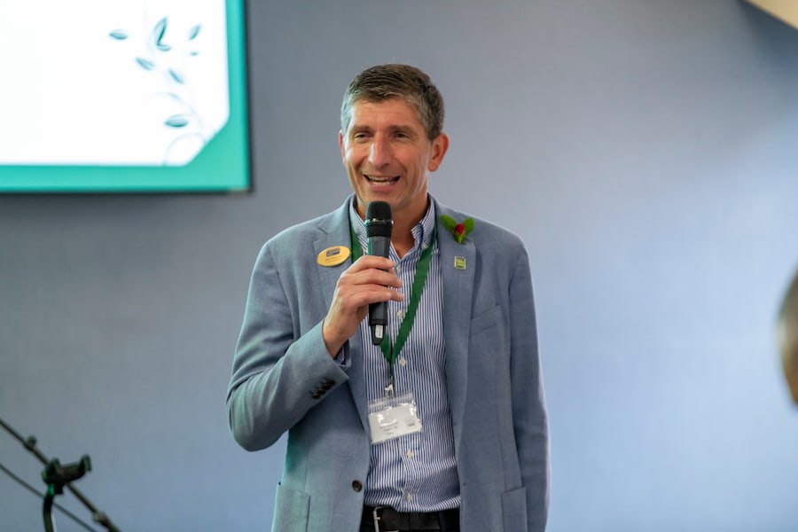 A man holding a microphone as he's speaking.