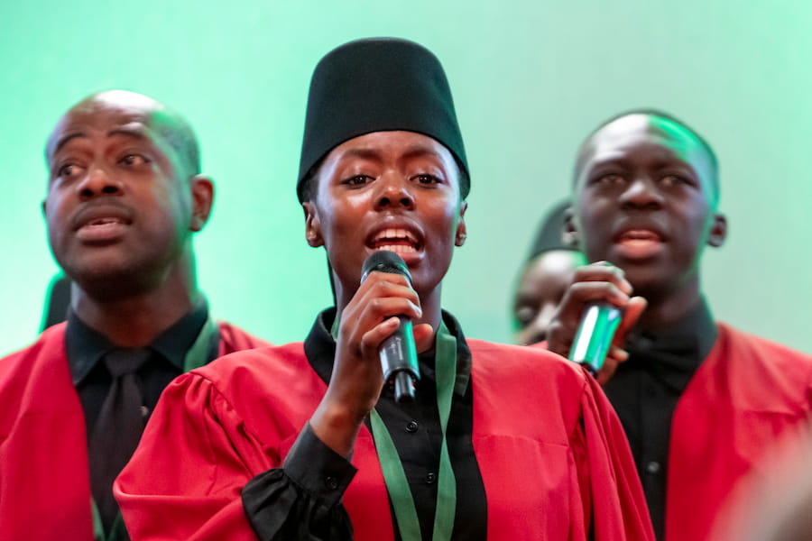 A woman holding a mic out in front of her face while singing.