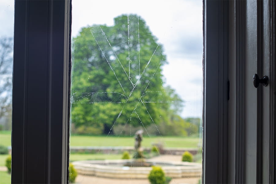 A window in the Woodlands Lounge showing the tape marks with the High Leigh fountain in the background.