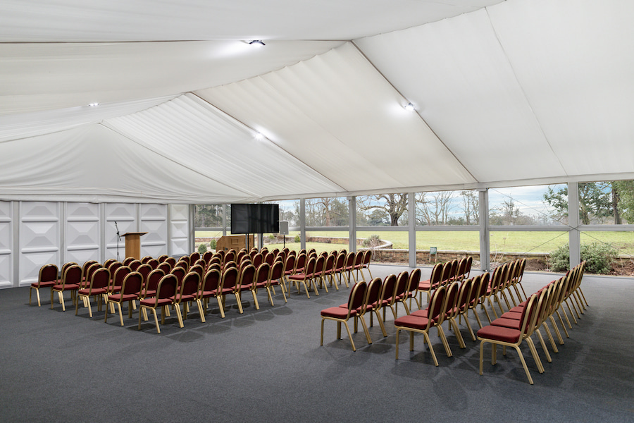 The Garden Suite interior set out in theatre-style showing 1 of 2 big screens and the stage with large windows overlooking the grounds.